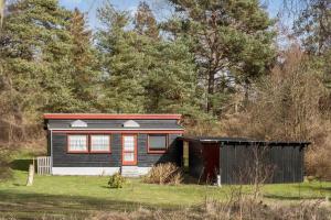 a small black house in the middle of a field at 5015-Askeby-Gormsvej-5 in Askeby