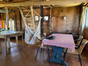 a room with a table and chairs and a hammock at El Rancho de Marcela in Cabo Polonio +13 photos