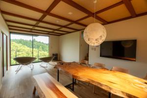 a dining room with a wooden table and a large window at なか富士 -Nakafuji- in Fujinomiya