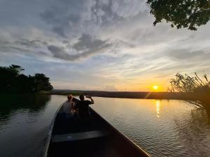 three people in a boat on a river at sunset at Playa Ganadito Ecolodge in Drake