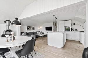 a white kitchen and living room with a table and chairs at S746-Stroby-Ladeplads-Lovsangervej-6 in Strøby Ladeplads