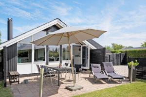 a patio with a table and chairs and an umbrella at S746-Stroby-Ladeplads-Lovsangervej-6 in Strøby Ladeplads