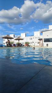 a swimming pool with umbrellas and people sitting in the water at Complejo Gran Chacha in Tanti +15 photos