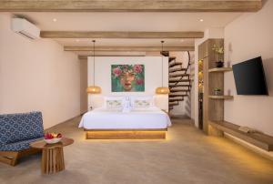 a bedroom with a bed and a tv in a room at Bohemian Beachfront Apartments in Pabean Buleleng
