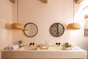 a bathroom with two sinks and two mirrors at Bohemian Beachfront Apartments in Pabean Buleleng +11 photos