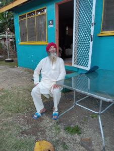 a man sitting on a chair in front of a table at Buddle Camping Ground in Nuku‘alofa
