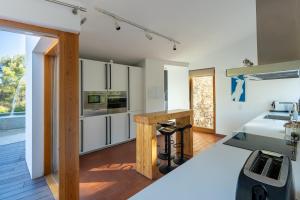 a kitchen with white cabinets and a wooden floor at Villa Can Tomeu Capdet in Sant Pere de Ribes
