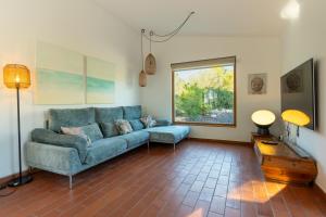 a living room with a blue couch and a window at Villa Can Tomeu Capdet in Sant Pere de Ribes