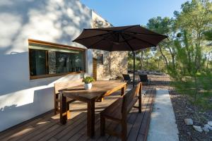 a wooden table with an umbrella on a deck at Villa Can Tomeu Capdet in Sant Pere de Ribes