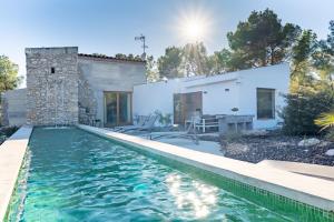 a villa with a swimming pool in front of a house at Villa Can Tomeu Capdet in Sant Pere de Ribes