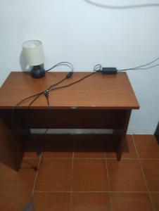 a wooden desk with a lamp on top of it at Hostal Claunorte in Calama +2 photos