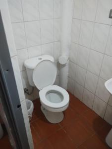 a bathroom with a white toilet and a sink at Hostal Claunorte in Calama