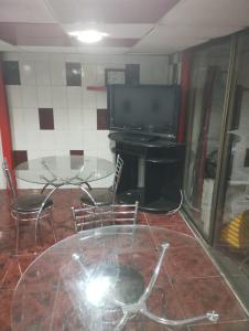 a room with a table and a television and a table and chairs at Hostal Claunorte in Calama