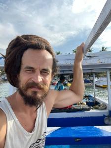 a man with a beard sitting on a boat at Buddle Camping Ground in Nuku‘alofa