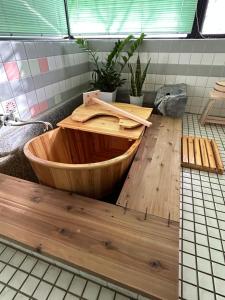 a wooden tub sitting on top of a bathroom floor at 里山でのんびり遊べる宿-風音翆舎 Kanon suisha in Kawaba