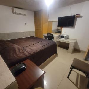 a hotel room with a bed and a television at hotel villa del sol chihuahua in Chihuahua +27 photos