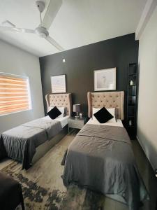 a bedroom with two beds and a window at sixfive negombo in Negombo
