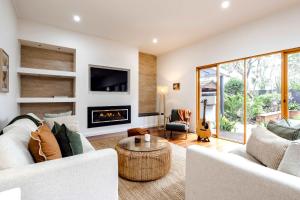 a living room with white furniture and a fireplace at The Greenhouse - Spa & Fire - Pet Friendly in Barwon Heads