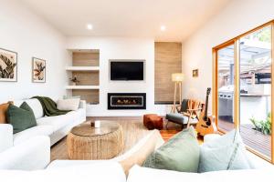 a living room with white furniture and a fireplace at The Greenhouse - Spa & Fire - Pet Friendly in Barwon Heads