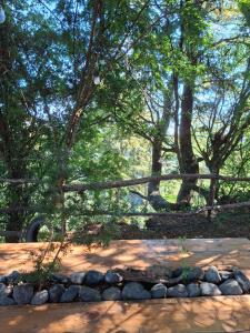 a pile of rocks next to a fence and trees at Casa Campo in Lago Ranco