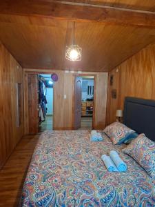 a bedroom with a large bed with blue pillows at Casa Campo in Lago Ranco