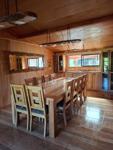 a dining room with a wooden table and chairs at Casa Campo in Lago Ranco