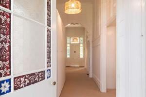 a hallway in a home with a chandelier at Perfect Point Lonsdale Cottage in Point Lonsdale