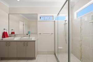 a bathroom with two sinks and a shower at Roderick Street 83, Moffat Beach in Caloundra +8 photos