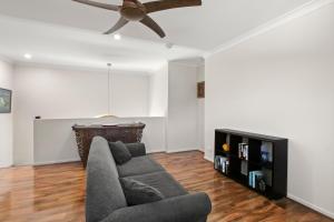 a living room with a couch and a ceiling fan at Roderick Street 83, Moffat Beach in Caloundra