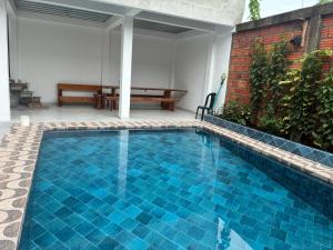 a blue swimming pool with a bench in the background at Hotel CHAFO in Leticia