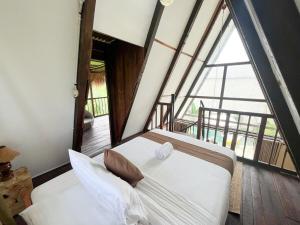 a bed in a room with a large window at The Phalosaa Villa unit Cabana in Ngaglik
