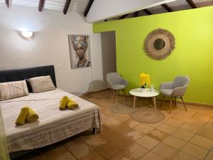 a bedroom with a bed and a table and chairs at Résidence la Baie de Ti t Anse in Pointe-Noire +79 photos