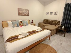 a bedroom with a large bed and a couch at Khaolak Beachhouse Kelolo in Khao Lak