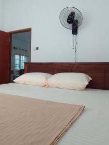 a bedroom with a bed with a fan on the wall at Ocean whisper residence in Ahangama