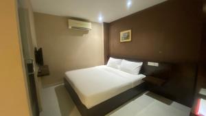 a small bedroom with a white bed in it at Hotel Vistana Micassa in Taiping