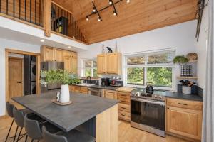 a kitchen with wooden cabinets and a table with chairs at Raven Haven Lodge by NW Comfy Cabins in Leavenworth