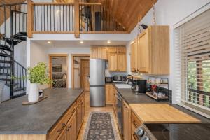 an open kitchen with wooden cabinets and counters at Raven Haven Lodge by NW Comfy Cabins in Leavenworth +33 photos
