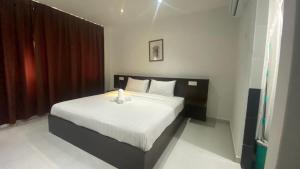 a bedroom with a large bed with white sheets at Hotel Vistana Micassa in Taiping
