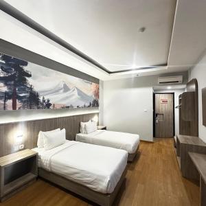 two beds in a room with a painting on the wall at Azana Style Hotel Lovina Bali in Lovina +43 photos
