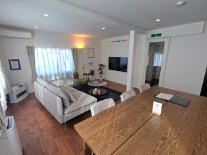 a living room with a table and a couch at Biei Central Villa 2 - Olive House in Biei +22 photos