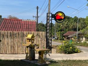 a bench and a bird house on a street at Ban Supattra in Ban Khlong Mat