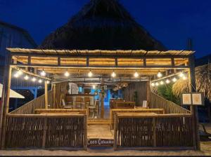 a restaurant with a wooden pavilion with a mountain in the background at Coco Cabaña Barú in Cartagena de Indias