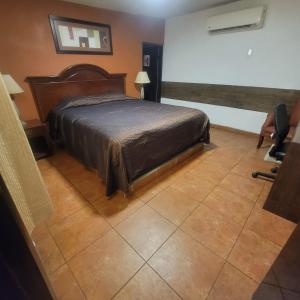 a bedroom with a bed and a tiled floor at hotel villa del sol chihuahua in Chihuahua