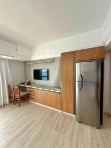 a kitchen with a stainless steel refrigerator and a desk at Tropical hotel Suíte Realeza in Manaus