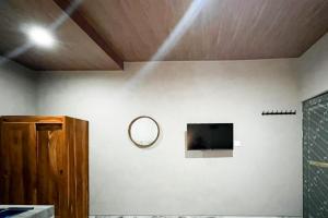 a room with a mirror on a wall with a tv at Pondok Sagara Mitra RedDoorz in Kapal