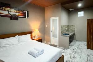 a bedroom with a white bed and a sink at Pondok Sagara Mitra RedDoorz in Kapal