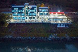 a large building sitting on top of the water at night at Yeosu K-Park Spa Pension in Yeosu