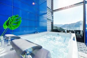 a bathroom with a bath tub with a large window at Camp Gate Pension Riverview Spa in Gapyeong
