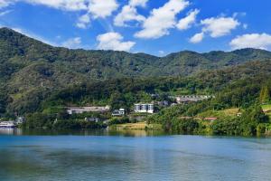 a view of a lake with mountains in the background at Camp Gate Pension Riverview Spa in Gapyeong