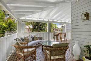 a porch with a couch and chairs and a table at Paddy's Place in Bangalow
